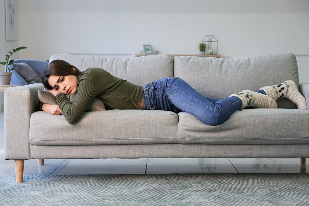 woman on couch struggling with an addiction relapse