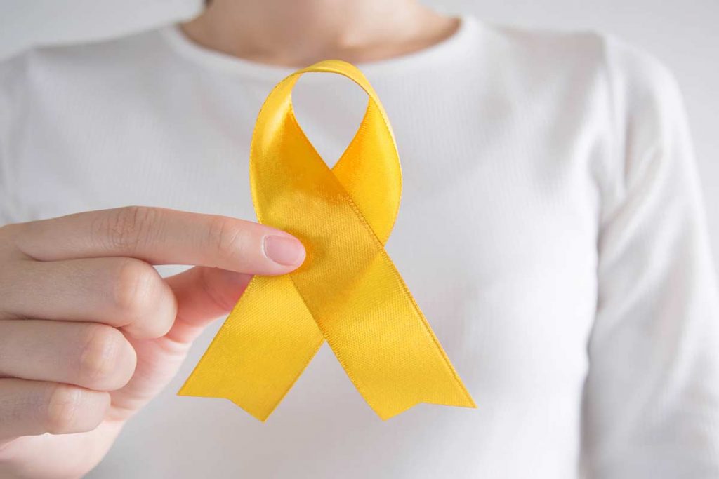 a person holding a yellow ribbon for world suicide prevention day