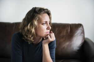 a woman on a couch thinking about meth and mental health